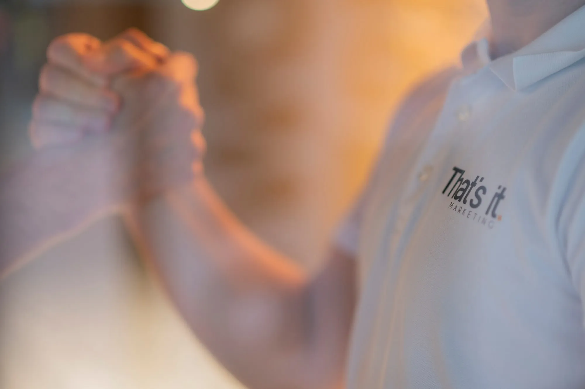 Handschlag zwischen einem Mitarbeiter von That’s it. Marketing im Poloshirt mit der Wortmarke und einem Kunden